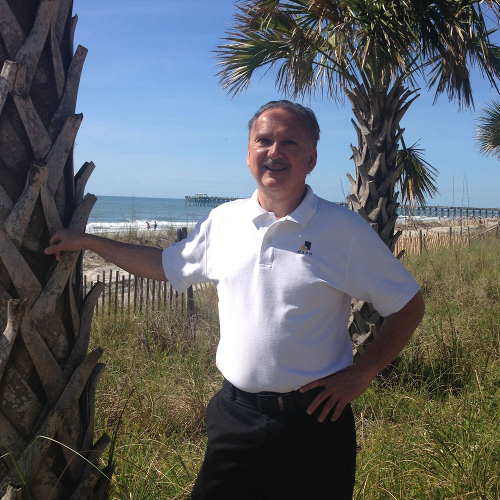 Robin R. Mach standing on a grassy dune